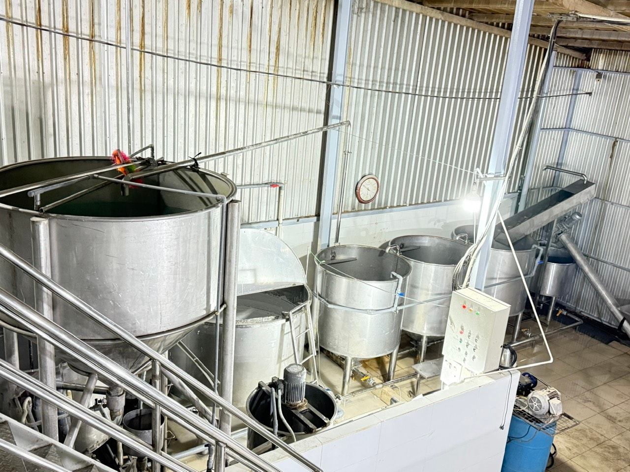 Cụm bồn inox và đường ống trong khu vực sản xuất.